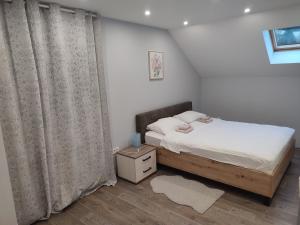 1 dormitorio pequeño con cama y cortinas en Apartman President, en Krapinske Toplice