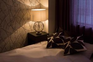 a bedroom with a bed with a lamp on a night stand at Hakuba Hatago Maruhachi in Hakuba