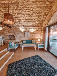 ein Wohnzimmer mit Sofas und Ziegelwand in der Unterkunft Le Blanc Bleu in Byblos