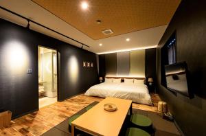 a bedroom with a bed and a table in it at Hakuba Hatago Maruhachi in Hakuba