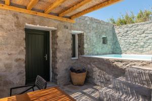 a patio with a pool and a table and chairs at Mykonos Drops in Platis Gialos