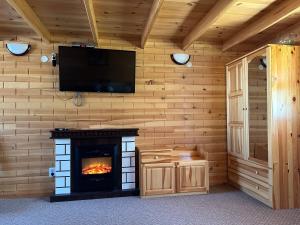 a living room with a fireplace and a flat screen tv at Еднофамилна дървена къщичка in Beli Iskar