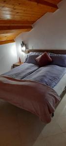 uma cama grande num quarto com tectos em madeira em Locanda San Martino em Massac