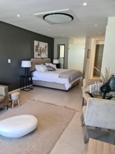 a bedroom with a large bed and a living room at Umhlangha Oceans Dunes in Umhlanga