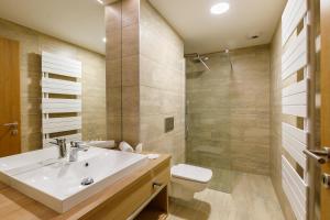 a bathroom with a sink and a toilet and a shower at Hotel Historia Malomkert in Veszprém