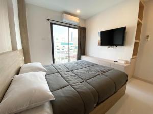a bedroom with a bed and a flat screen tv at Mangkon Hostel in Bangkok