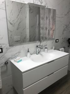 uma casa de banho branca com um lavatório e um espelho em WHITE HOUSE em Verona