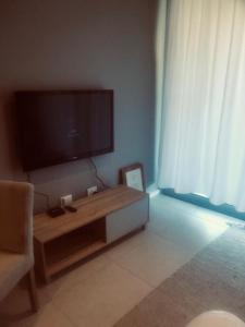 a living room with a large flat screen tv on the wall at Umhlangha Oceans Dunes in Umhlanga