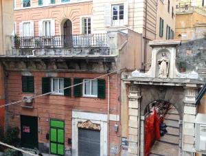 ein altes Gebäude mit grünen Türen und einem Balkon in der Unterkunft Hotel Bernheof in Genua