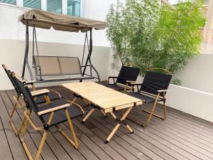 a picnic table and two chairs and an umbrella on a deck at Mangkon Hostel in Bangkok