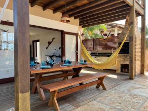a patio with a hammock and a table and bench at BEACH HOUSE Barra Grande - CASA INTEIRA - WHOLE HOUSE in Barra Grande