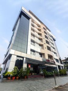 a large building with plants in front of it at Hotel Seven Hills in Trivandrum
