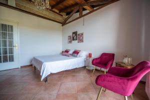 sypialnia z białym łóżkiem i 2 różowymi krzesłami w obiekcie Rosè House w mieście Camino
