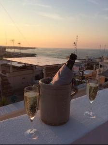 uma garrafa de champanhe num balde de gelo numa mesa com dois copos em FONTEblu B&B em Polignano a Mare