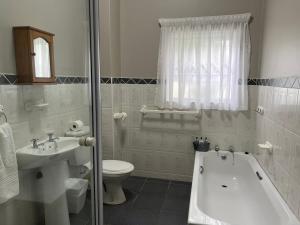 een badkamer met een bad, een toilet en een wastafel bij Oceanway Self-catering Accommodation in Gonubie