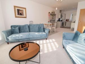 a living room with two blue couches and a table at Beach House in Rhos-on-Sea