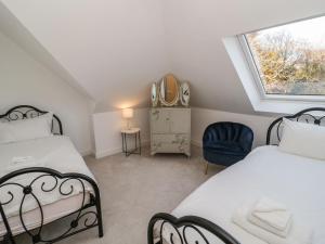 a attic bedroom with two beds and a window at Beach House in Rhos-on-Sea