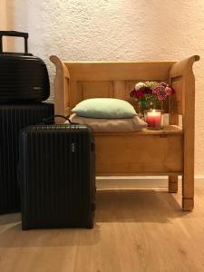 a bed with a pillow and a candle and a suitcase at Gästehaus Hotel Maria Theresia - Kennenlernpreise für den Frühling am Schliersee in Schliersee