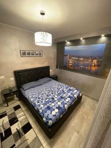 1 dormitorio con 1 cama con una pintura en la pared en Dave’s house, en Reggio Emilia
