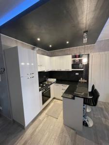 une cuisine avec des placards blancs et un comptoir noir dans l'établissement Dave’s house, à Reggio d'Émilie