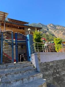 a set of stairs with a gate in front of a house at Dog n Hill in Kasol