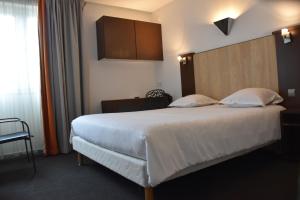 1 dormitorio con 1 cama blanca grande y cabecero de madera en Adonis Arc Hotel Aix, en Aix-en-Provence