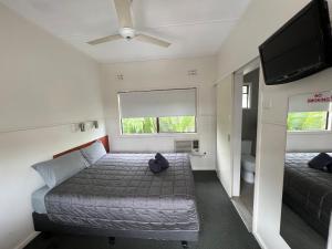 a small bedroom with a bed and a flat screen tv at Hi-Way Motel Grafton - Contactless in Grafton