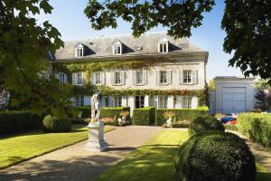 una gran casa blanca con una estatua en el patio en Hôtel Le Choiseul, en Amboise