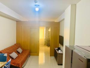 Kleines Zimmer mit einem Bett und einem TV in der Unterkunft Sea Residences JO Alano's Place in Manila