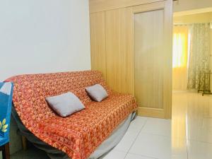 ein Schlafzimmer mit einem Bett mit zwei Kissen darauf in der Unterkunft Sea Residences JO Alano's Place in Manila