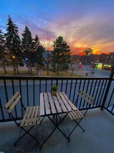 einen Tisch und zwei Stühle auf einem Balkon mit Blick auf den Sonnenuntergang in der Unterkunft Maison Cartier Montreal in Montreal