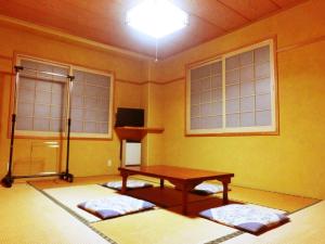 a room with a table and two windows at Oyado Uemasa in Nozawa Onsen