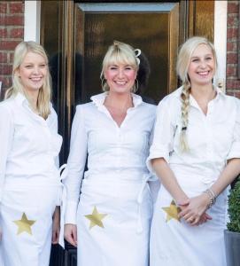 two women in white dresses with gold stars on them at Supreme City Penthouse in Leeuwarden
