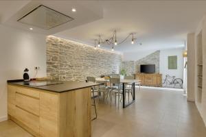een keuken en eetkamer met een stenen muur bij OS ORMOS Casa Rural - Apartamentos - Habitaciones in Espuéndolas