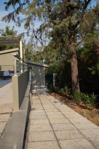 a sidewalk with a fence and a tree at 8 Boutique Suites in Nea Potidaea