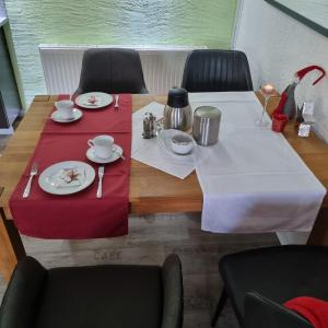 einen Tisch mit Tellern und Küchenutensilien oben in der Unterkunft Pension Elisabeth am Elberadweg in Prödel