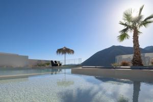 バリにあるMayana Luxury Villa, an infinite blue experience, by ThinkVillaのヤシの木と山を背景にしたスイミングプール