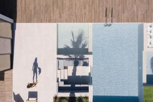 バリにあるMayana Luxury Villa, an infinite blue experience, by ThinkVillaのプールサイドのスケートボードに乗る人の絵画