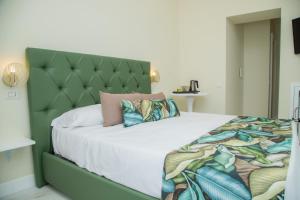 Schlafzimmer mit einem großen Bett mit einem grünen Kopfteil in der Unterkunft Gentile Suite in Neapel