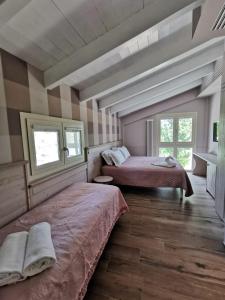 a bedroom with two beds and two windows at Agriturismo e Acetaia la Vedetta in Castelvetro di Modena