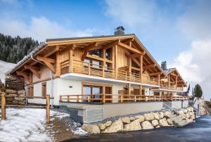 a large wooden house with a wrap around balcony at TERRESENS - L'ALTARENA in Les Saisies