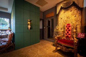 Pokój z krzesłem i zieloną ścianą w obiekcie Queen Love Homestay w mieście Hualian
