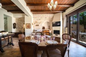 uma sala de jantar com mesa e cadeiras em Arhontariki Luxury Apartment em Panormos - Rethymno