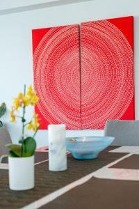 a table with a red painting on the wall at Condor Apartments by Gold Coast Premium in Gold Coast