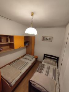two beds in a small room with a light at Apartment Ana in Rijeka