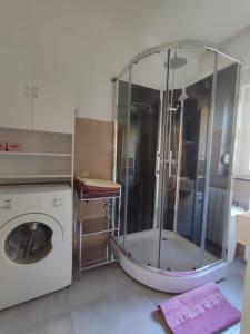 a bathroom with a shower and a washing machine at Apartment Ana in Rijeka