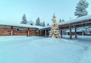 a cabin in the snow with a snow covered yard at Kuukkeli Log Houses Porakka Inn in Saariselka