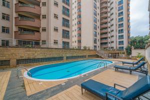 a swimming pool in front of a large building at Valley Arcade Towers - Kilimani in Nairobi