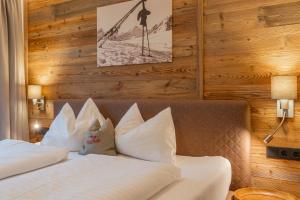 ein Hotelzimmer mit 2 Betten und weißen Kissen in der Unterkunft AlpenParks Appartements Maria Alm in Maria Alm am Steinernen Meer