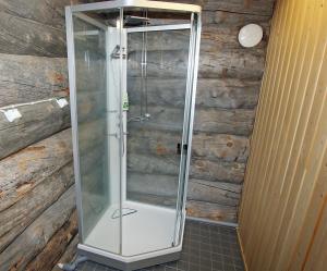 a shower with a glass door in a bathroom at Kuukkeli Log Houses Porakka Inn in Saariselka